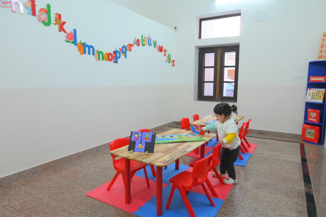 Children playing happily on the preschool playground in front of the school building